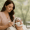 An esthetician applying a white clay facial mask to a client at Genesis Medspa.