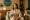 a woman in a spa robe smiling and holding a glass of water in the genesis medspa relaxation lounge.